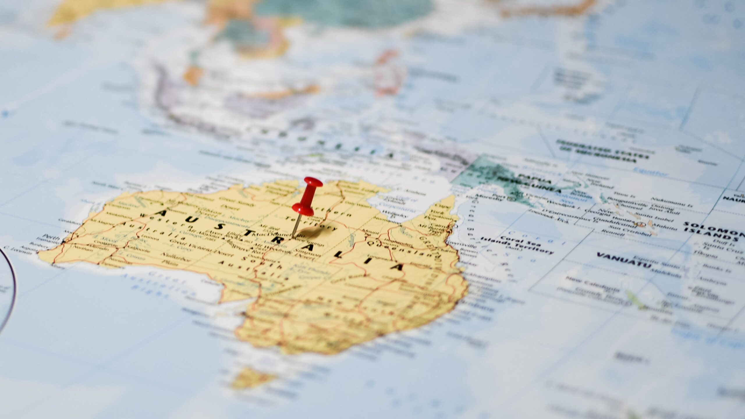 A close up of a map with Australia the focal point. A pin is stuck through the middle of Australia. This image is for the Trilogy Funds September 2025 economic update that investigates when the Reserve Bank of Australia may next cut interest rates